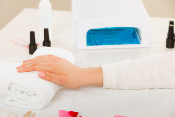 Woman hand on towel, next to manicure set