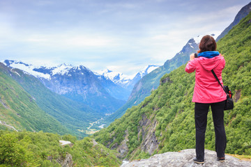 Tourist with camera taking picture in mountains Norway