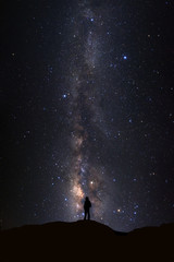 Naklejka premium Landscape with milky way, Night sky with stars and silhouette of man standing on high moutain
