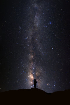 Fototapeta Landscape with milky way, Night sky with stars and silhouette of man standing on high moutain