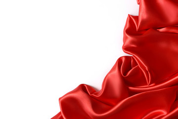 Close up of ripples in red silk fabric. Satin textile background with free copy space on white.