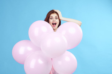 Fototapeta na wymiar girl in a huge pile of inflatable balls very happy