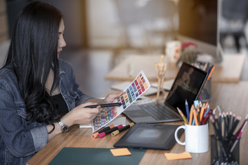 Fototapeta premium asian woman designer working with color samples for selection interior design in modern office