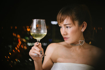 one asian woman with a flute of wine on white