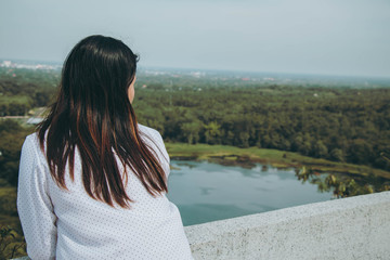 an Asia woman standing thinking,looking  to something with loneliness and sadness.