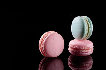 Pink and blue macarons isolated on black background