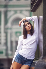 Young woman in casual clothes posing on a city street .The concept of easy casual wear .
