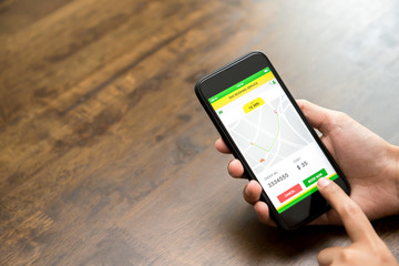 Woman hand touching smartphone screen confirming booking taxi online via application