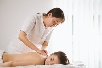 Fototapeta na wymiar Tibetian massage in spa salon for young woman