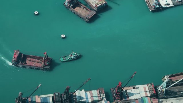 Hong Kong - October 2017: Elevated view of industrial port. Boat pulling crane vessel. 4K resolution.