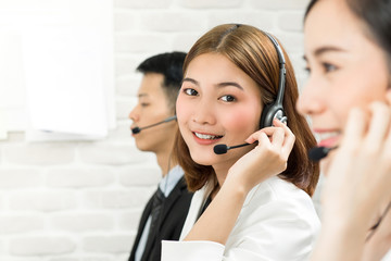 Smiling beautiful Asian woman telemarketing customer service agent in call center