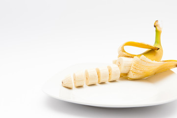 Fresh, healthy sliced banana on white plate isolated on white background.