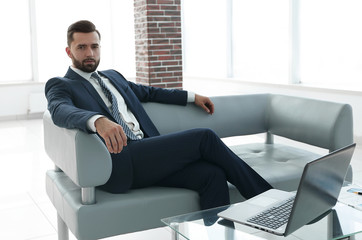 businessman sitting in the lobby of a modern office.