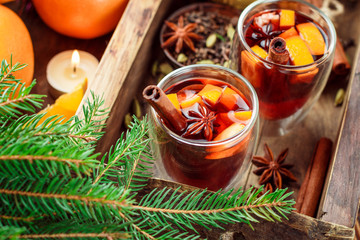 Mulled wine - Christmas hot drink with orange, cinnamon, cardamom and anise in a glass cups. New year. Selective focus