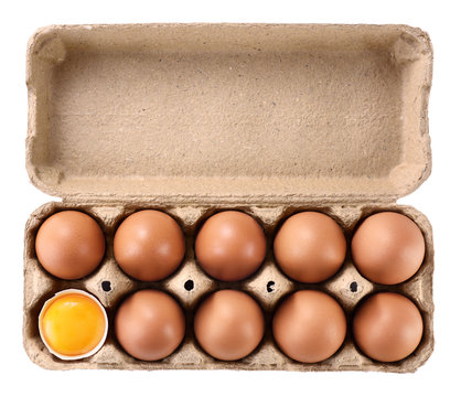 Carton egg box with eggs isolated on white background. Broken egg, yolk.