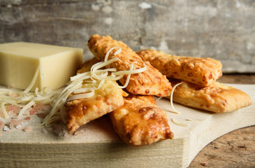 Home baked salty sticks with cheese on rustic wooden background. 