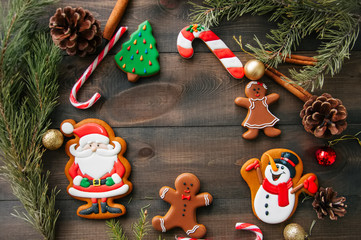 Christmas background. Different shapes of gingerbread cookies and christmas decorations on a wooden backdrop. Copy space and top view.