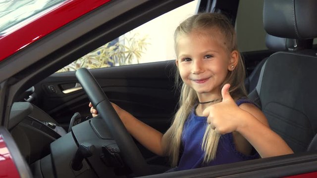 Beautiful cute girl turns the steering wheel of a car