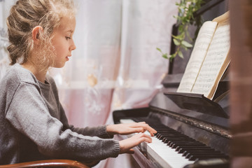 Little girl learning to play the piano.