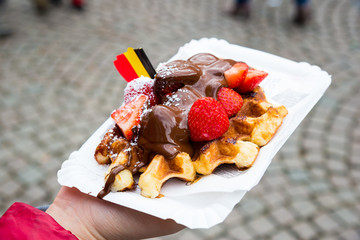 Belgium waffle with chocolate sauce and strawberries, Bruges city background - 182808720