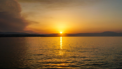 Obraz premium sunset on the sea to the mountains beautiful view