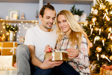 Sweet couple opening Christmas gifts