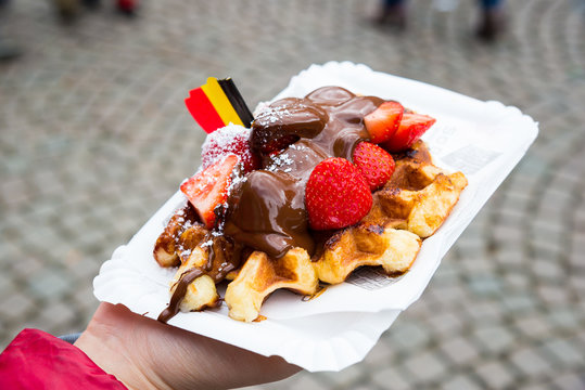 Belgium waffle with chocolate sauce and strawberries, Bruges city background