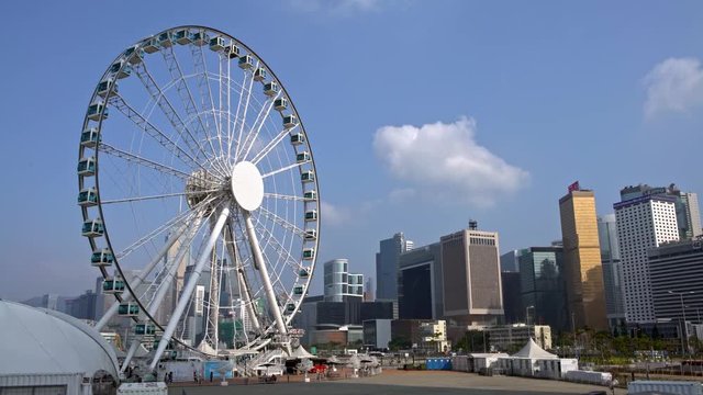 4K Observation big ferris wheel and amusement rides in central Hong Kong. Downtown skyline in the background-Dan