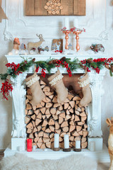 Beautiful holiday decorated room with Christmas tree, fireplace and with presents. Cozy winter scene. White interior.