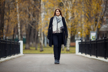 Full-length photo of girl in black coat in autumn park