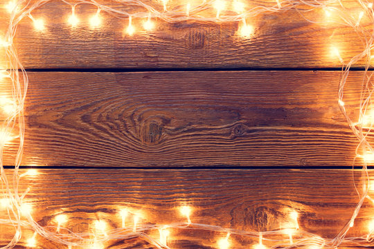 Photo of wooden surface with burning garland around perimeter.