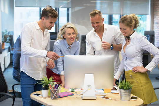 Group of people in office looking at computer