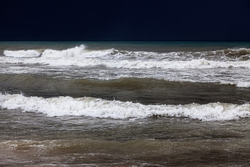 A cloud hangs over the sandy beach