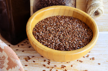 Brown flax seeds  in wooden bowl  and flaxseed oil on a rustic table. Superfood: linseeds are high in omega-3 fatty acids, essential for good health. Healthy eating ,vegan  and raw diet concept.