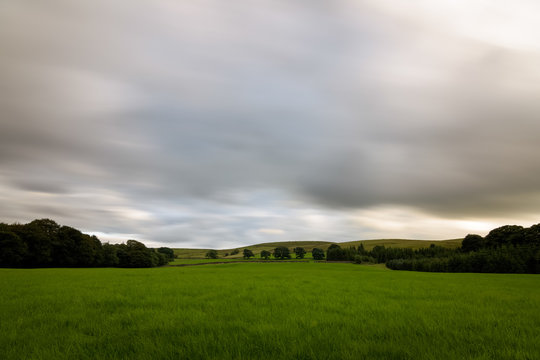 Clouds long exposure over british green countryside England