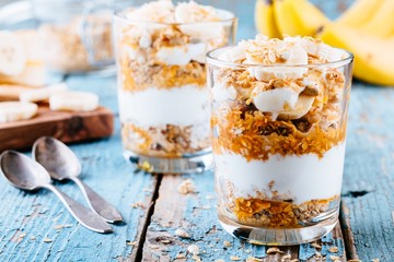 healthy breakfast parfait. homemade granola with natural yogurt, banana and caramel sauce