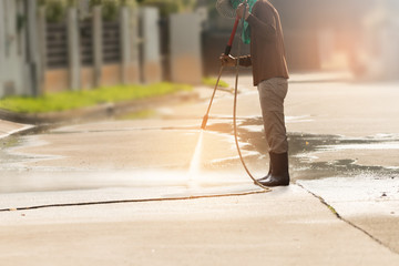 High pressure deep cleaning..Worker cleaning driveway with gasoline high pressure washer...