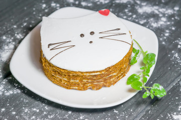 Cake and honey cakes with white marshmallows on a white plate on black wooden background closeup 