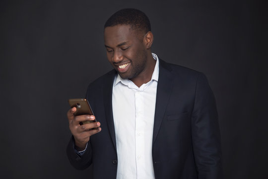 Successful confident black businessman. Handsome african american executive business man holds in hand smart phone.