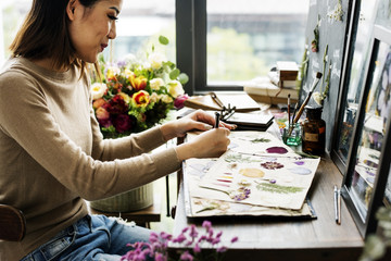 Woman writing as she creates floral project