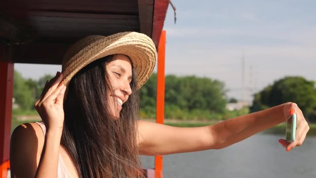 Young Happy Mixed Race Tourist Woman Taking Selfie Photo Using Mobile Phone. Smiling Hipster Carefree Girl Traveling on Thai Boat. Thailand. 4K Slow Motion.