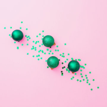 New Year Composition. Christmas Green Balls And Confetti On Pink Background. Flat Lay, Top View