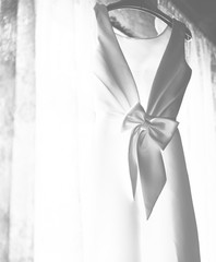 Closeup of White Wedding Dress Hanging by the Window Grayscale