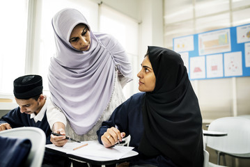 diverse muslim children studying in classroom