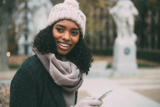 Young black woman on the mobile phone near the royal palace in winter .