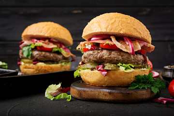 Big sandwich - hamburger burger with beef,  tomato, pickled cucumber and fried bacon