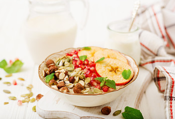 Tasty and healthy oatmeal porridge with apples, pomegranate and nuts. Healthy breakfast. Fitness food. Proper nutrition