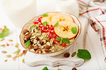 Tasty and healthy oatmeal porridge with apples, pomegranate and nuts. Healthy breakfast. Fitness food. Proper nutrition