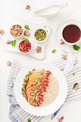 Tasty and healthy oatmeal porridge with apples, pomegranate and nuts. Healthy breakfast. Fitness food. Proper nutrition. Top view.