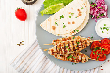Minced Lula kebab grilled turkey (chicken) with fresh vegetables. Top view